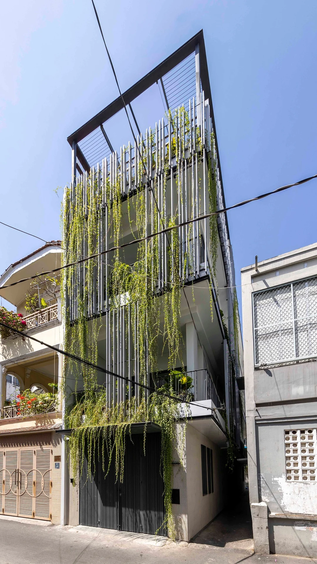 Mặt tiền Vy House sau cải tạo với rèm cây xanh và hệ lam